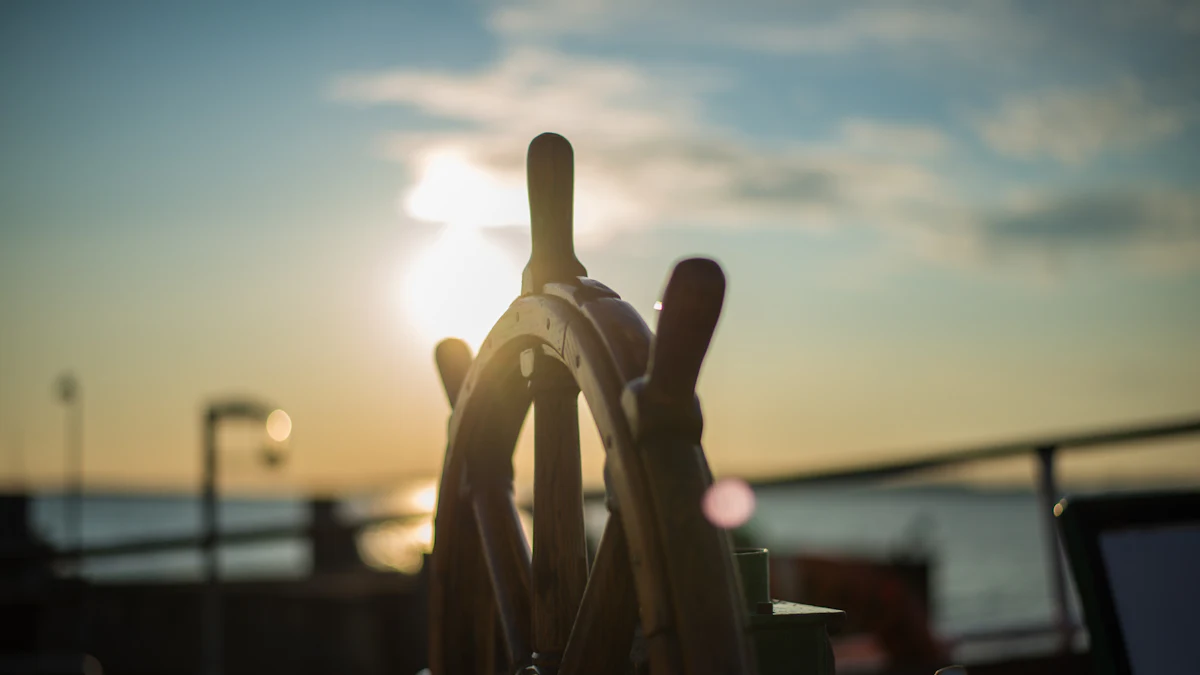 Silhouette of a ship’s wheel against a low sun over the water